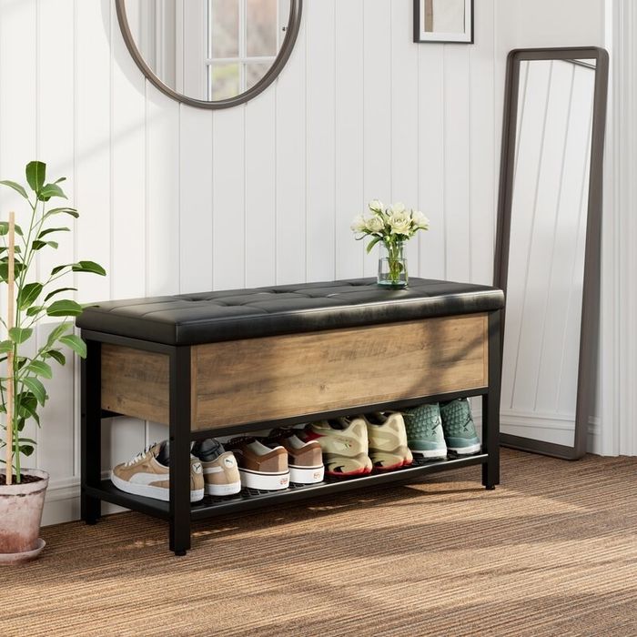 The rustic brown bench placed near an entryway.