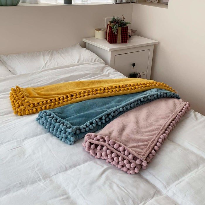Three fleece blankets with pom-pom edges