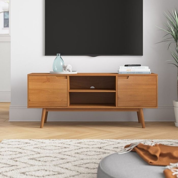 The TV stand with a flat-screen TV mounted above, offering a sleek, minimalist look to your living room setup.