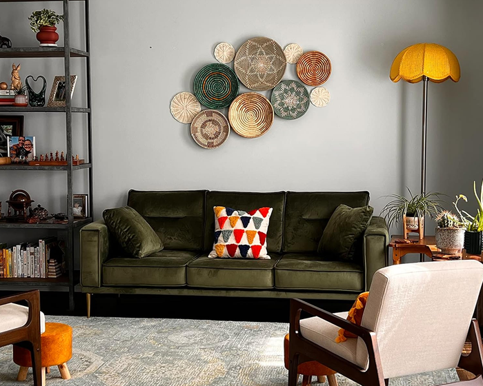 A reviewer’s set of turquoise wall baskets displayed on a wall above a green sofa