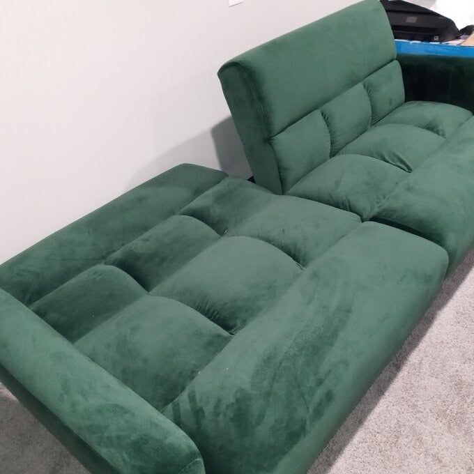 A reviewer photo showcasing the futon in green, half in the upright position and half flat
