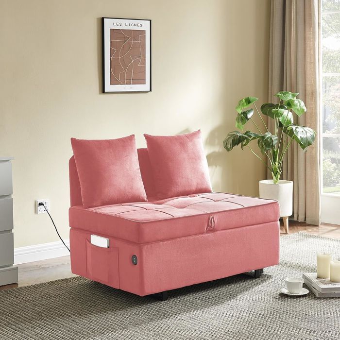 A sleek modern pink loveseat with plush cushions, placed in a cozy living room beside a potted plant and wall art. Perfect for compact spaces.