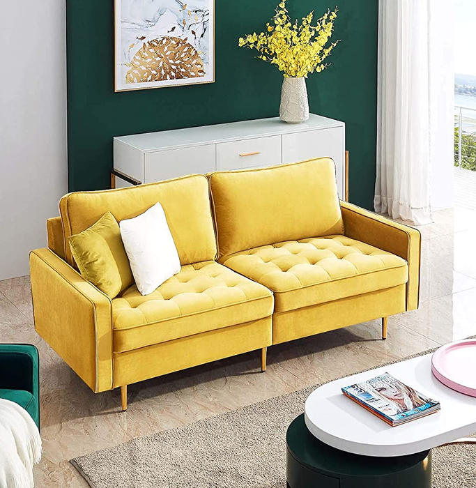 A yellow mid-century modern sofa adorned with two pillows, adding a pop of color to any space.