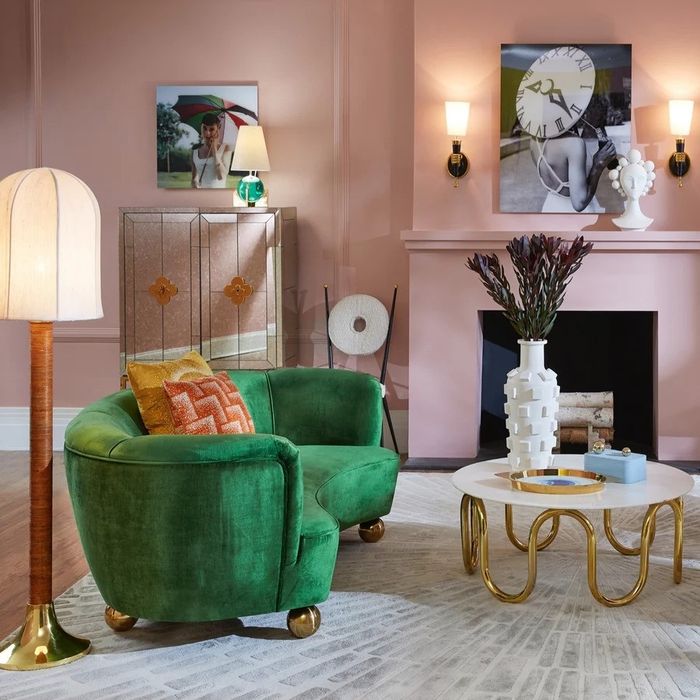 A stylish living room featuring a plush green sofa, a golden-trimmed sideboard, and a trendy coffee table — ideal for chic interior decor inspiration.