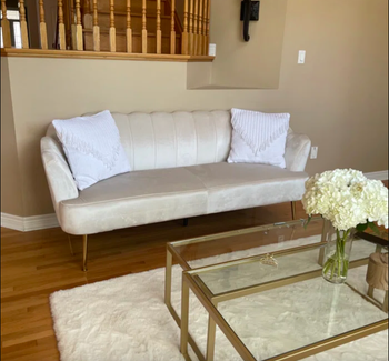 photo from a reviewer showcasing the scalloped white velvet sofa in a living room setting