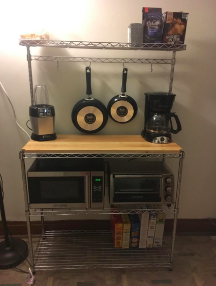 A reviewer's photo showing their collection of pots and pans neatly arranged on the rack.