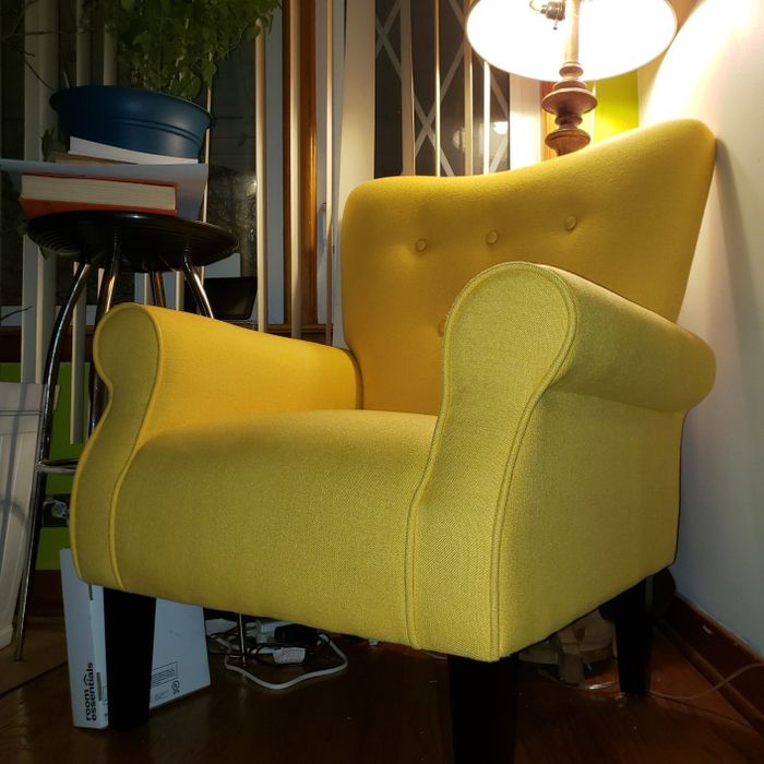 A mid-century modern style armchair nestled in a cozy living room space.