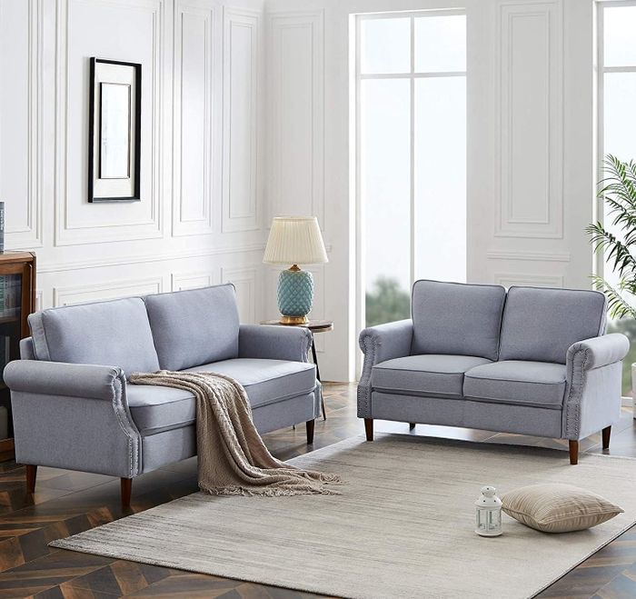 Two sky blue sofas paired with a throw blanket and a small table with a lamp