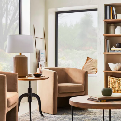 A cozy brown chair with rounded arms, positioned in the corner of a living room, adding warmth to the space.
