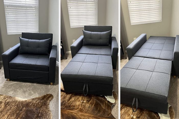 A reviewer’s image showing a gray tufted convertible chair in its seating position, with the matching footrest extended, and fully reclined into a bed form atop a carpet.