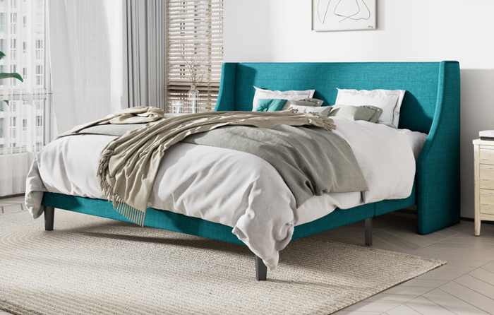 A lifestyle image featuring a turquoise low-profile upholstered bed, creating a stylish and serene atmosphere.