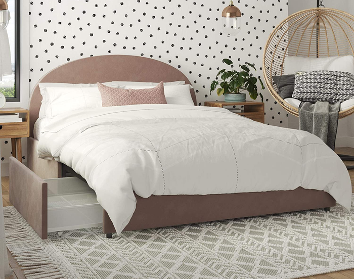 Lifestyle photo of a blush pink velvet half-moon platform bed in a bedroom