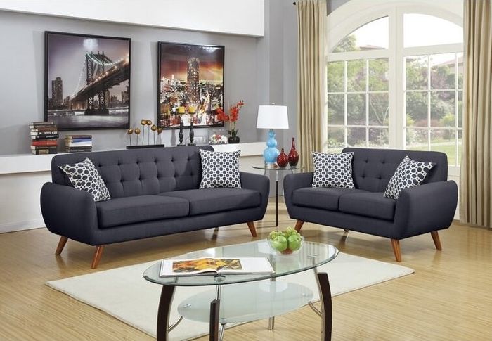 Two gray sofas placed around a white rug and a glass coffee table