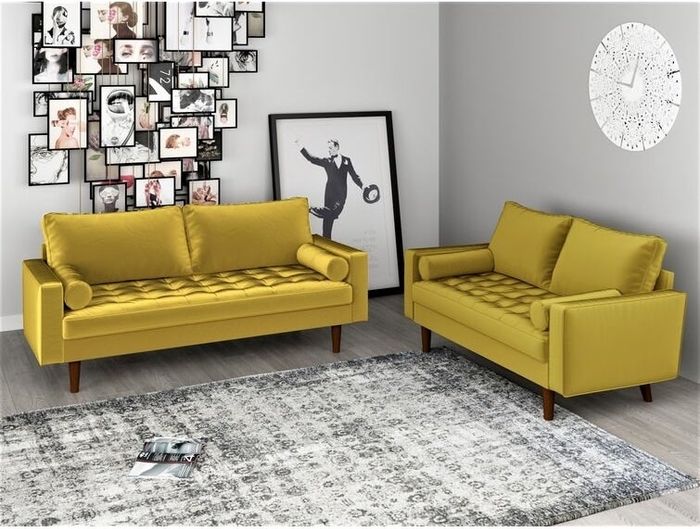 Two yellow velvet sofas surrounding a gray and white rug