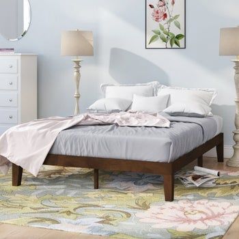 Wooden platform bed with cozy bedding arranged on top