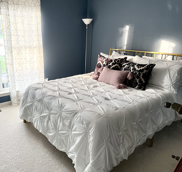 A reviewer's image of the gold metal bed frame in their bedroom