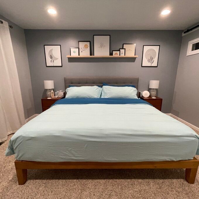 A reviewer's photo of the wooden platform bed set up in their bedroom