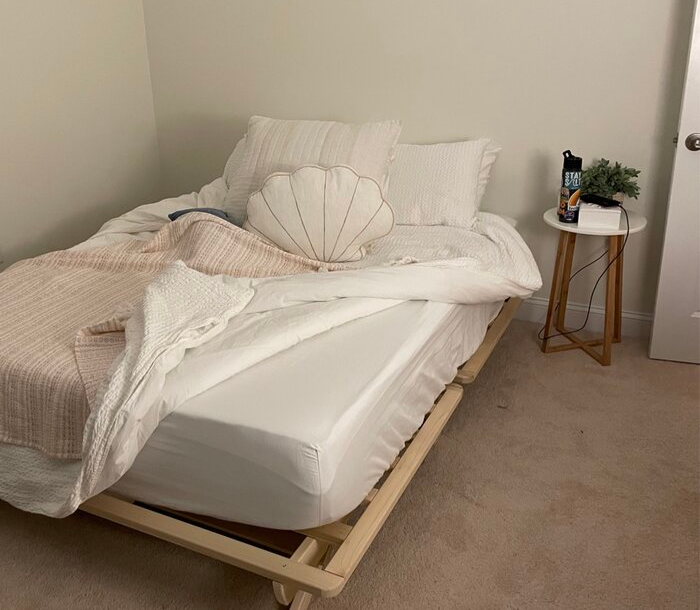 Reviewer's photo of a wooden low-profile platform bed