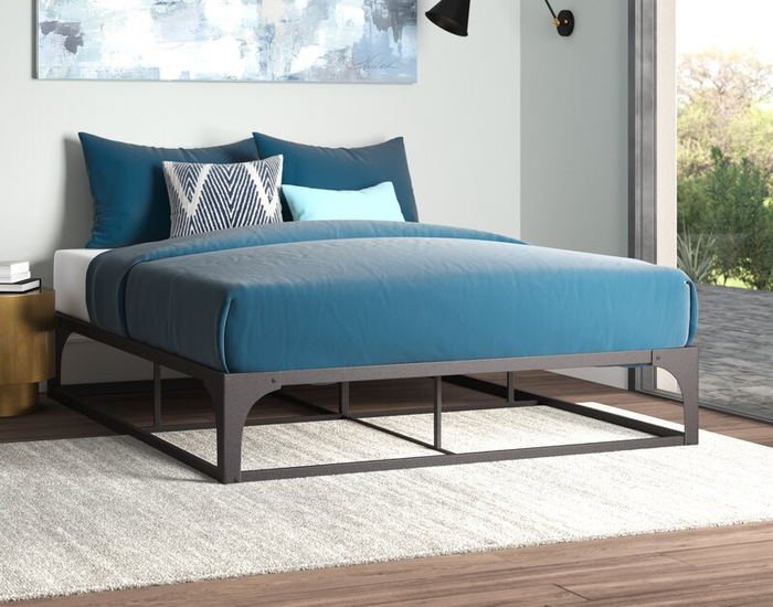A lifestyle image of a gray steel bed frame in a cozy bedroom setting.
