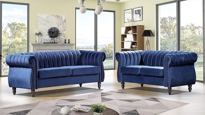 Navy blue velvet sofa and loveseat arranged around a brown coffee table