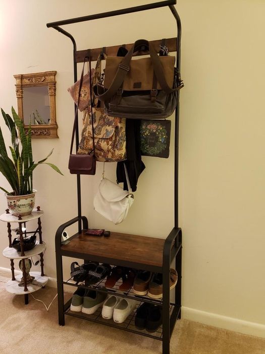 reviewer photo of a functional coat rack with bags hanging on the hooks and shoes neatly arranged on the shelves