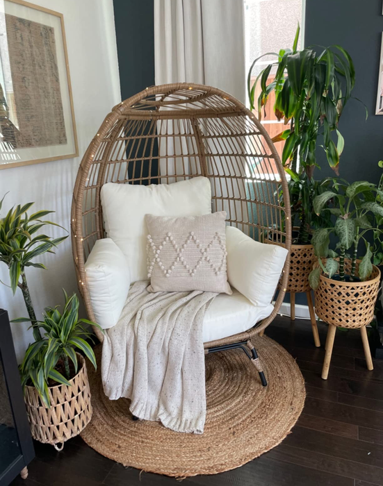 A reviewer’s photo featuring the chair adorned with white cushions, adding a touch of elegance to the space.