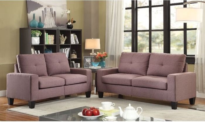 Two brown fabric couches surrounding a cream-colored rug and a coffee table