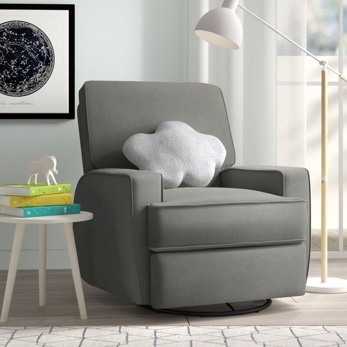 A snug grey armchair with a cloud-shaped pillow, accompanied by a small table with books and a lamp. Behind the chair, a constellation map decorates the wall art.