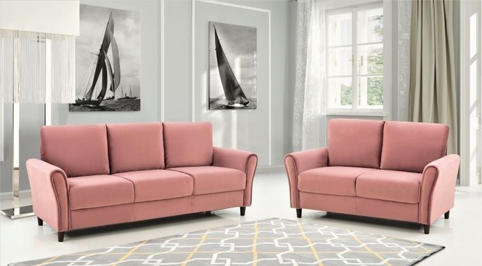 Two soft pink velvet sofas surrounding a rug with shades of gray, yellow, and white