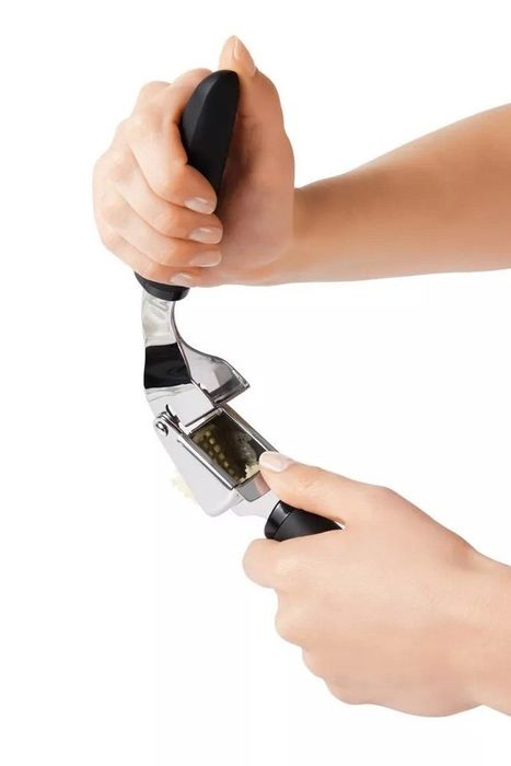 The garlic press in action, crushing garlic cloves