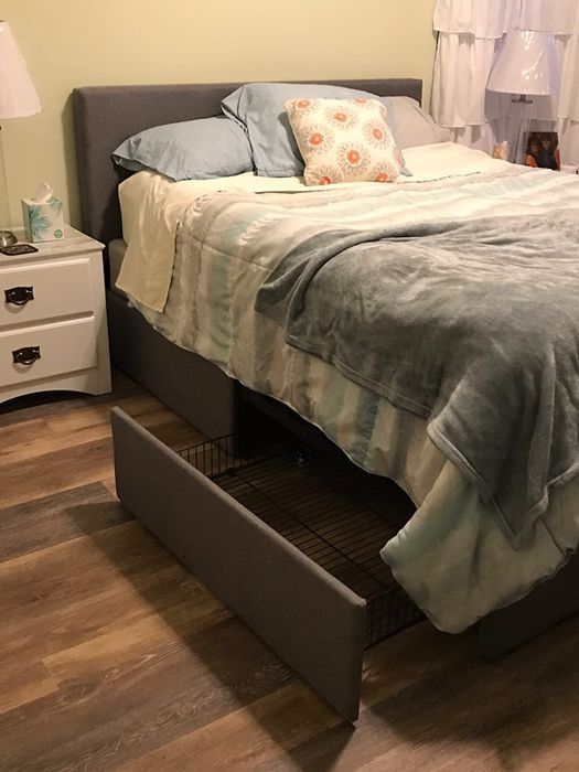 Reviewer's photo of the platform bed frame in a bedroom, with a drawer pulled open