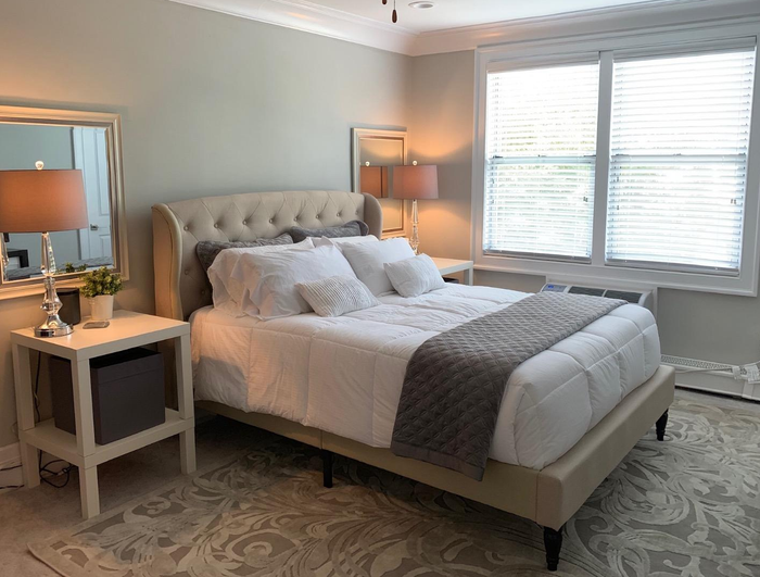 A photo shared by a reviewer showing the tufted beige linen bed frame beautifully placed in a serene bedroom environment.