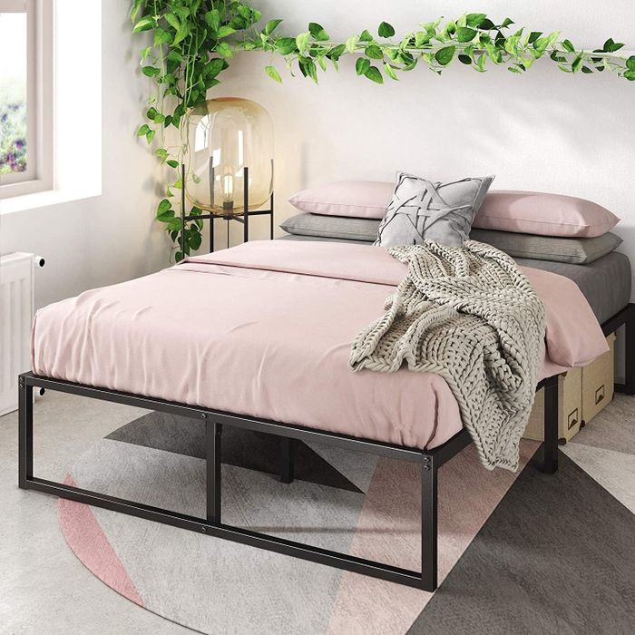 Image showcasing the bed frame with pink and gray sheets