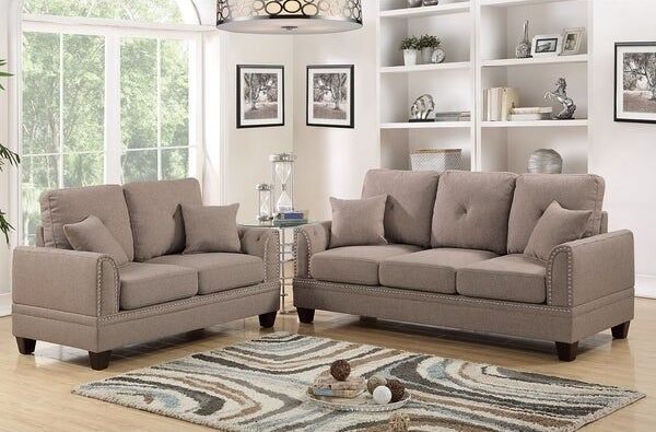 Two light brown couches surrounding a blue, brown, and dark brown swirling rug
