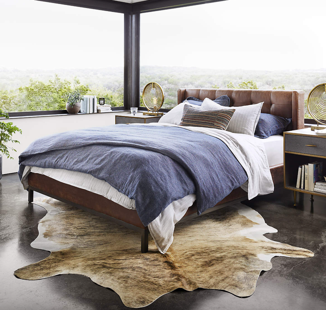 A leather platform bed bathed in sunlight, creating a warm and inviting ambiance in a beautifully styled bedroom.
