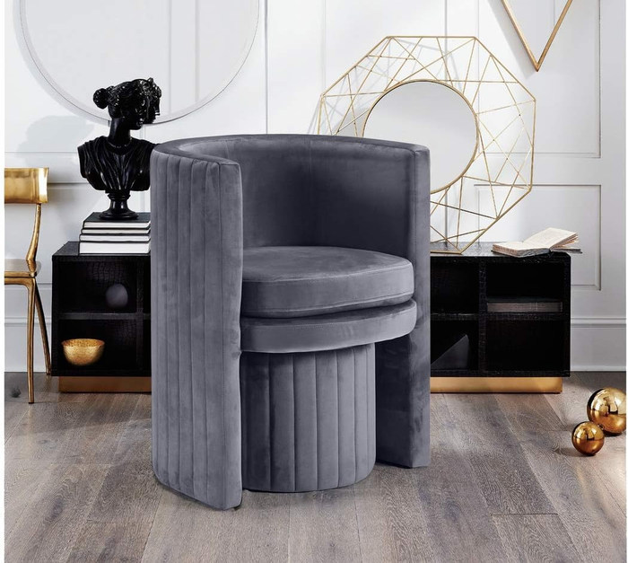 The gray chair with the ottoman neatly tucked beneath, saving space while maintaining a stylish look.