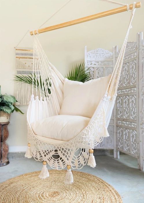 A crochet hammock chair in white, designed for hanging.