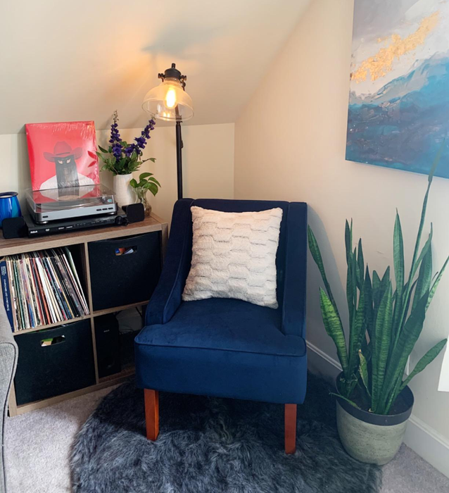 A reviewer's photo showcasing their blue velvet armchair, complete with a white throw pillow for added charm.