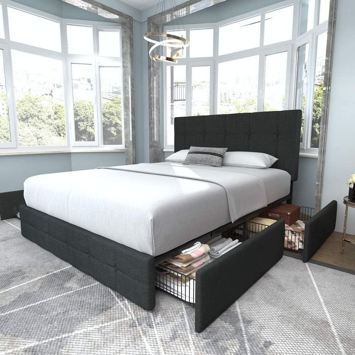 Lifestyle image of a gray upholstered platform bed with drawers open for storage