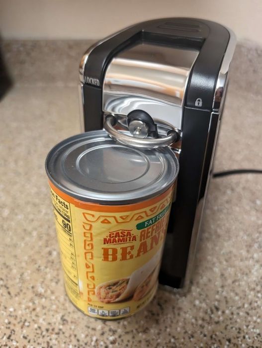 Electric can opener on a kitchen counter effortlessly opening a can of Casa Mamita Refried Beans