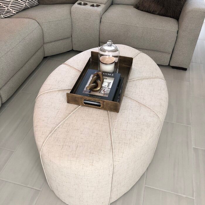 A reviewer's photo of an ivory oval ottoman coffee table