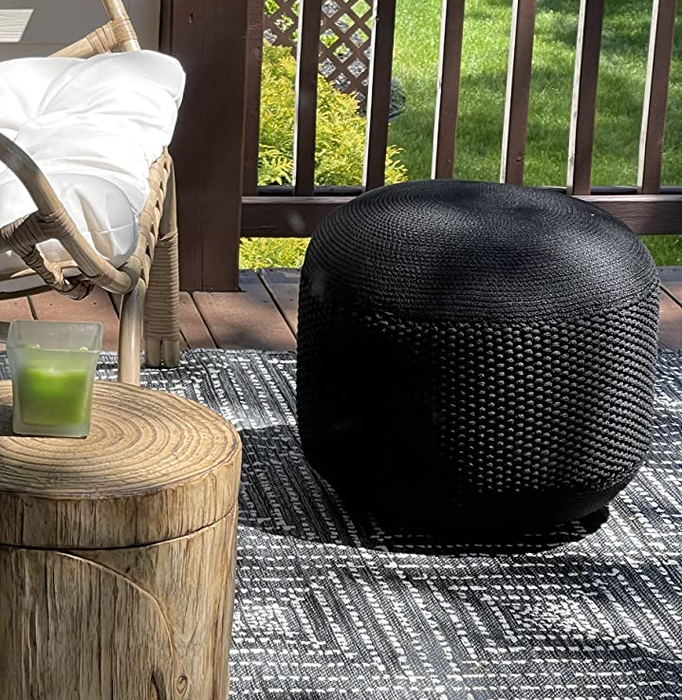 A reviewer's image showcasing a sleek black ottoman.