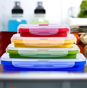 Four colorful containers of different sizes, collapsed flat and neatly stacked on top of each other