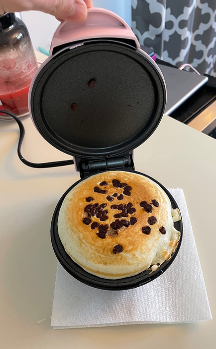 A chocolate chip pancake being made inside the mini maker.