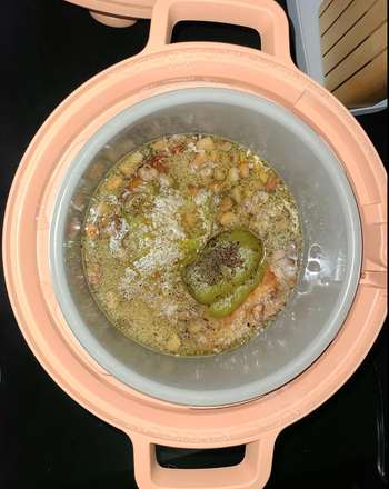 A cooker filled with soup inside, ready to serve a warm meal.