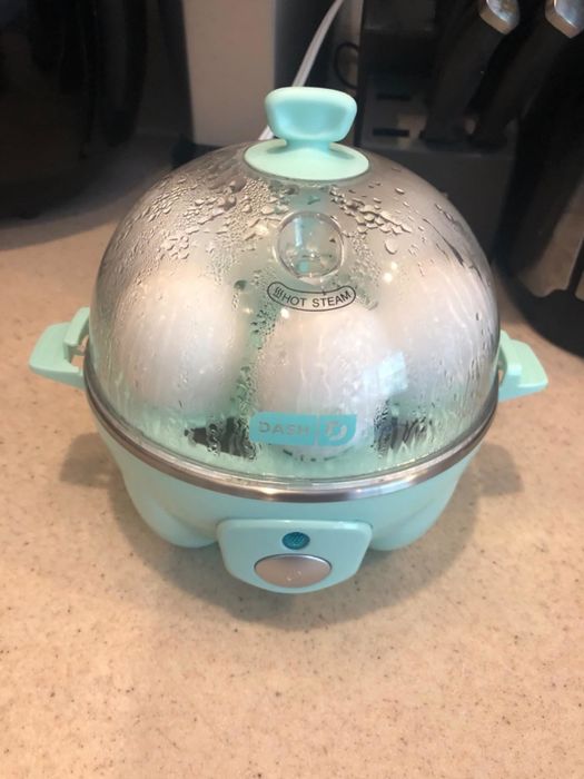 The egg cooker with eggs inside boiling away