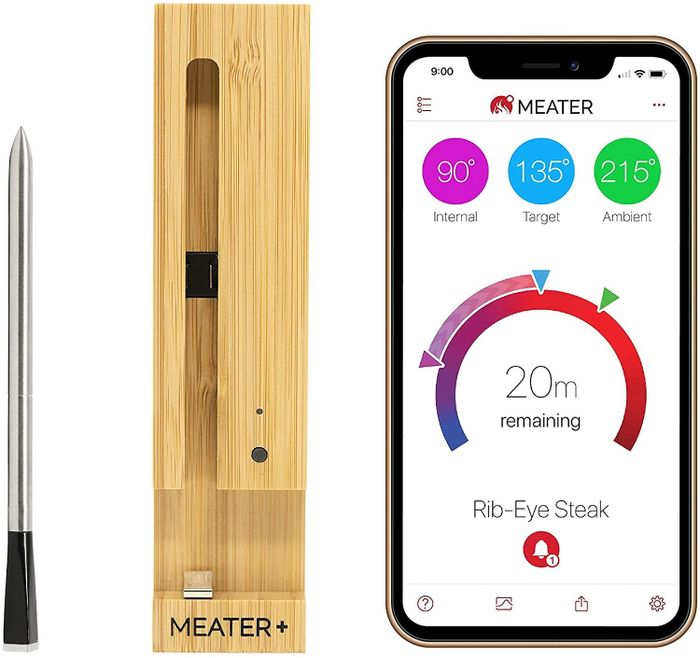 A meat thermometer, a charging dock, and a smartphone displaying an app on the screen