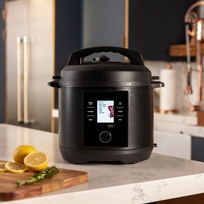 A sleek black smart pressure cooker sitting on a countertop