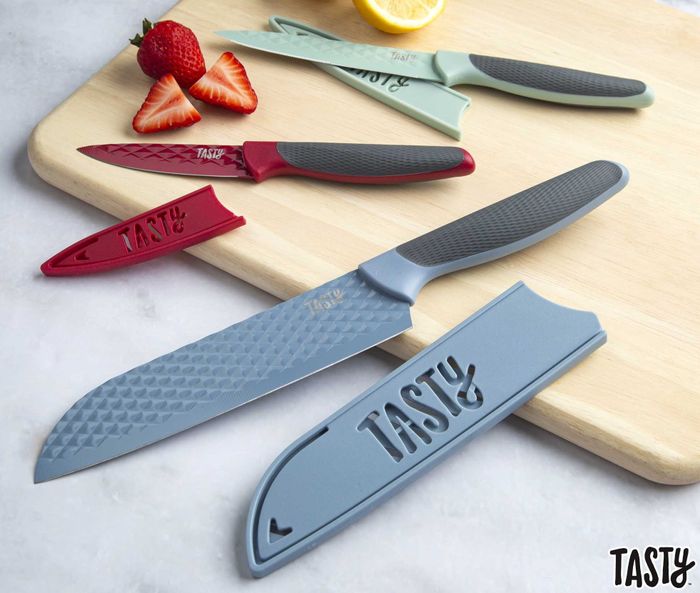 A set of kitchen knives, complete with matching blade guards, arranged on a wooden board, with an emphasis on the protective advantages of these guards.