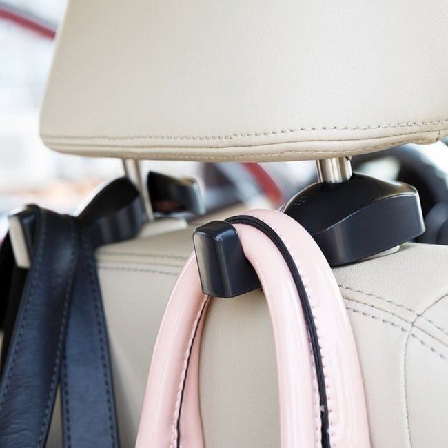 A purse hanging from a black hook attached to the front seat headrest pole